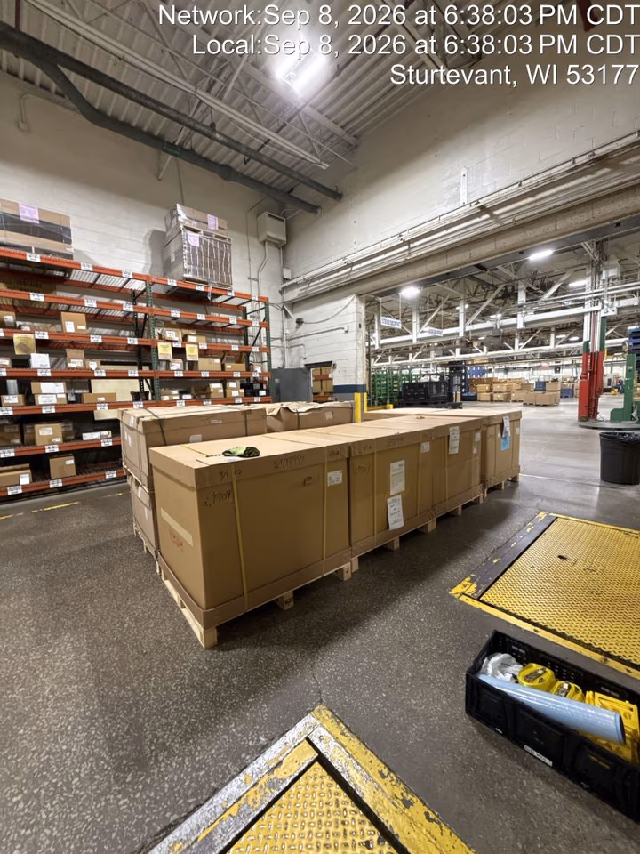 Crated air freight staged on a receiving floor in Sturtevant, Wisconsin after a dedicated box-truck delivery from O’Hare